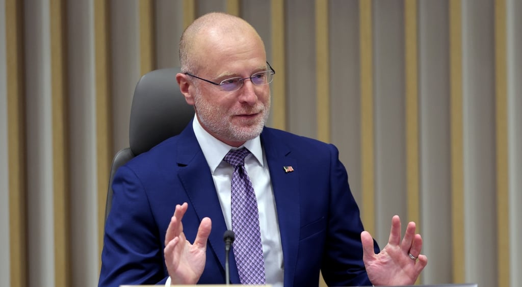 Chairman Brendan Carr, white bald man, blue suit, white collar shirt, light purple tie,