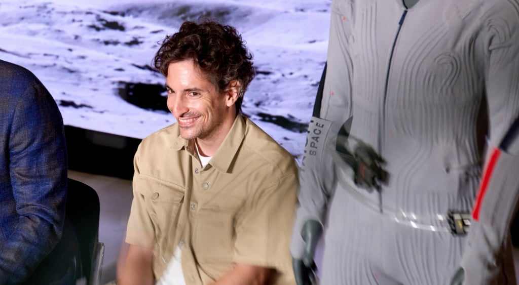 Lorenzo_Bertelli, sand color shirt, white t-shirt, moon ground on screen, black curly hair, smile