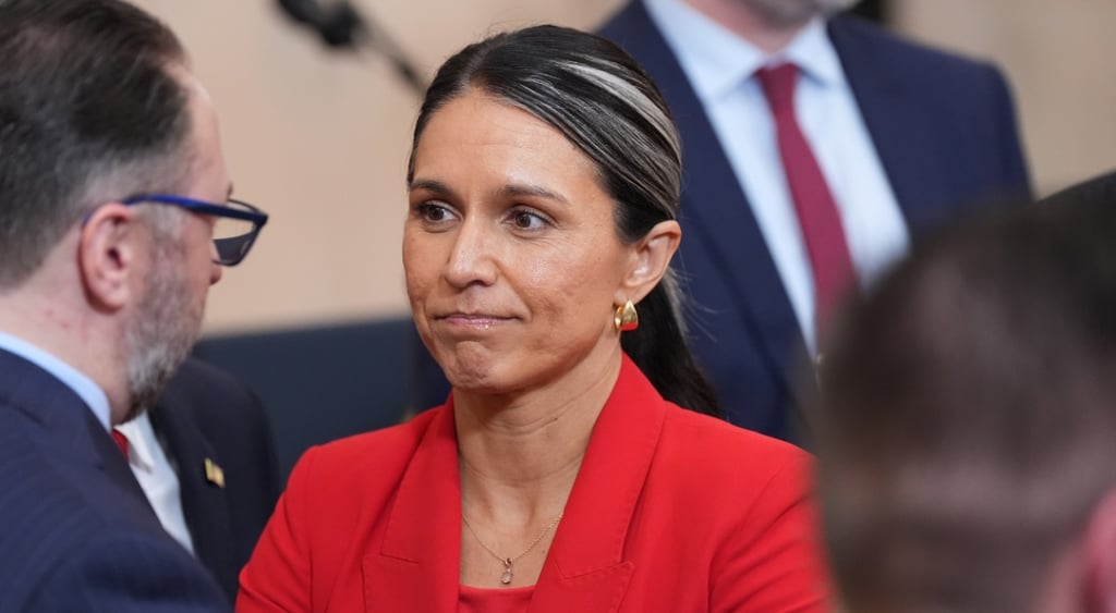 Tulsi Gabbard, long black hair, red blazer, red top, other dark blue blazers, white collar shirt, red tie