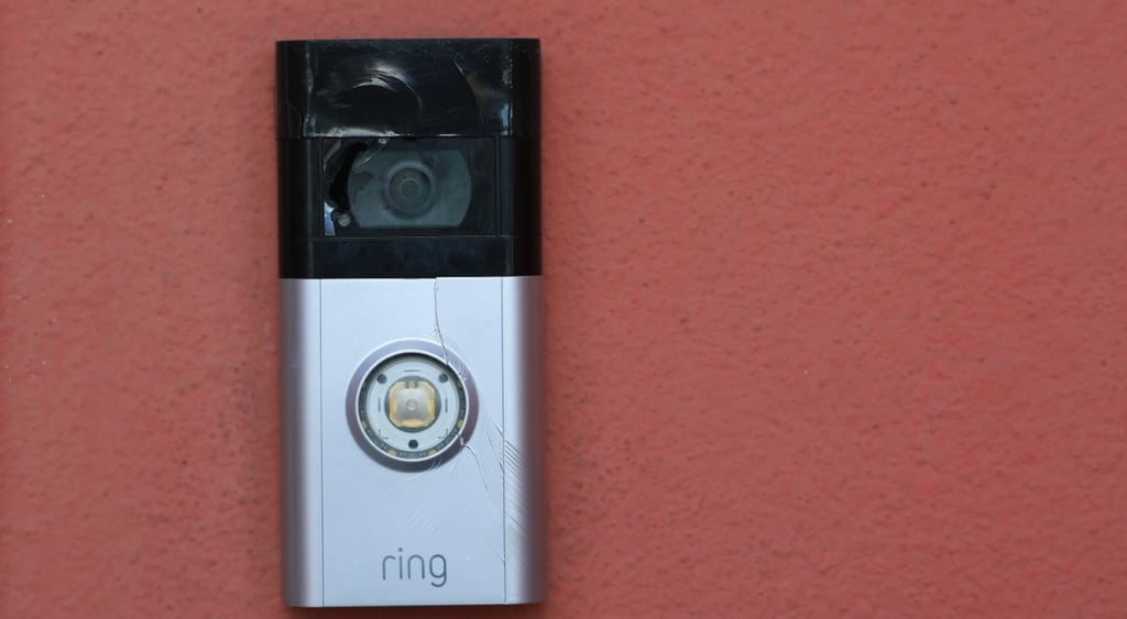 amazon ring doorbell camera, grey and black, red wall