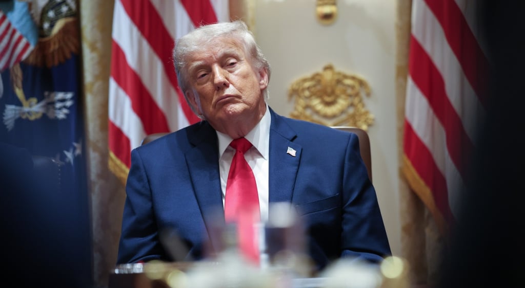 donald trump, two US flags, one flag pin in dark blue suit, white collar shirt, red tie, blonde hair