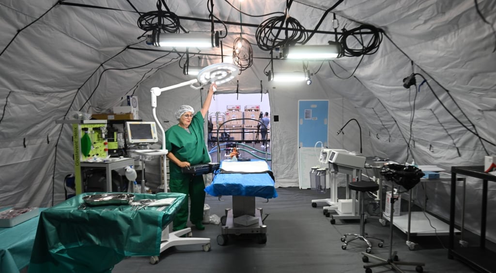 operation room, nurse in green scrubs, blue surgical bed, medical equipment