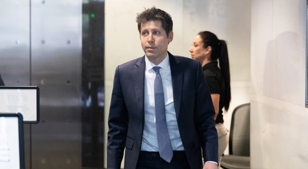 sam altman, grey elevator door, woman, long black hair in polytail