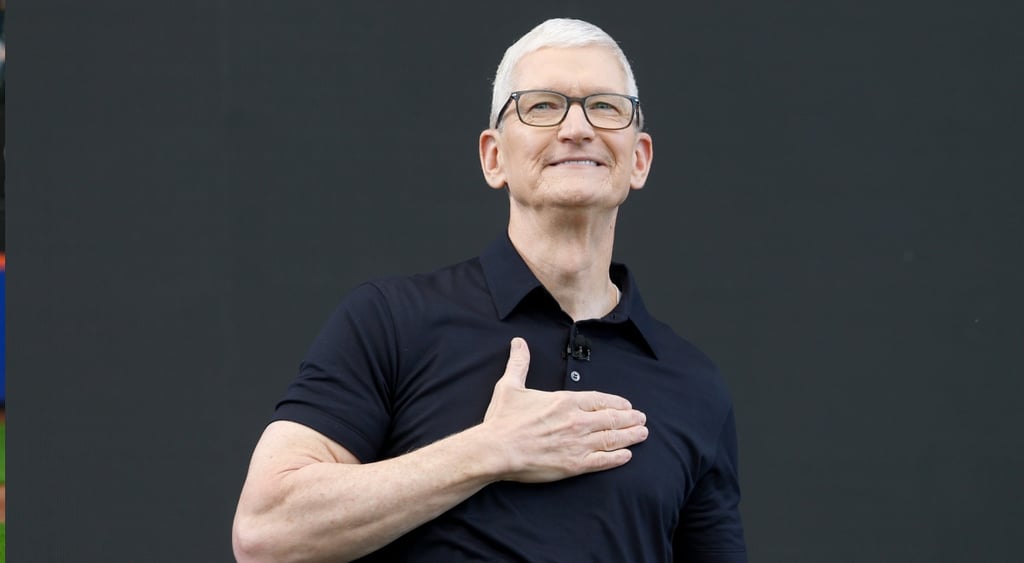 Apple CEO Tim Cook, right hand on heart, white male, grey white hair, left hand on heart