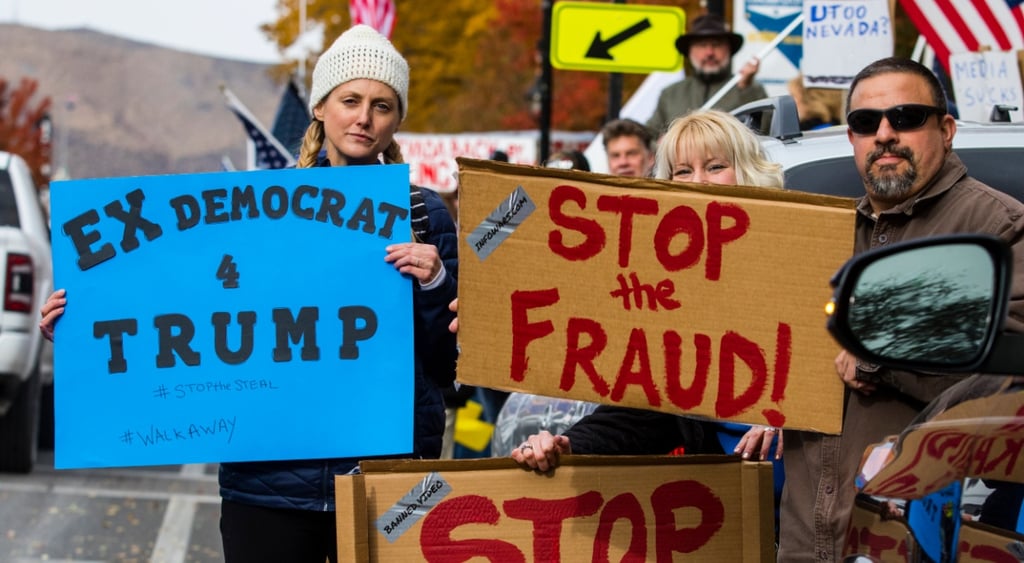 ex democrat trump sign i nblue, blonde woman in braids, white warm hat, stop the fraud sign