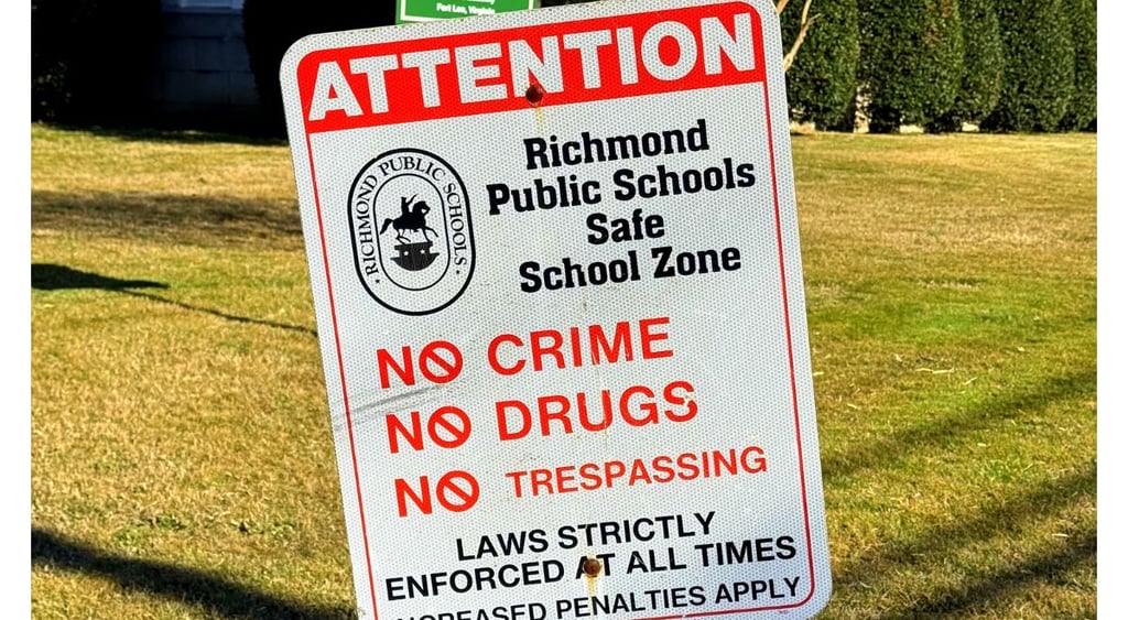 Richmond City Public School sign in forefront, high school in background