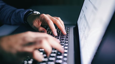 a man typing on a keyboard
