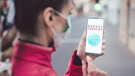 Woman using a phone with the coronavirus tracking app installed