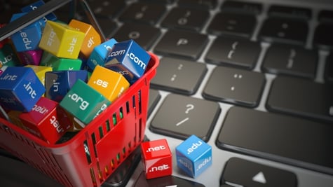 Shopping basket with domain names on computer keyboard
