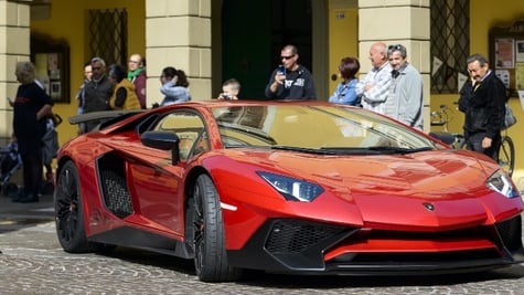 Red Lamborghini and people around it