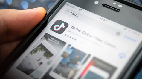 Man holding a phone with TikTok open