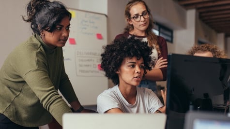women in work environment discusing by computers
