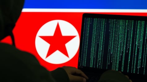 A computer in front of the North Korean flag
