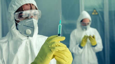 Doctor preparing syringe with virus vaccine to treat a patient