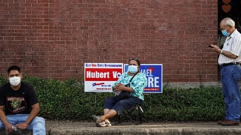 People wait in line to cast their ballots for the upcoming presidential election as early voting beg