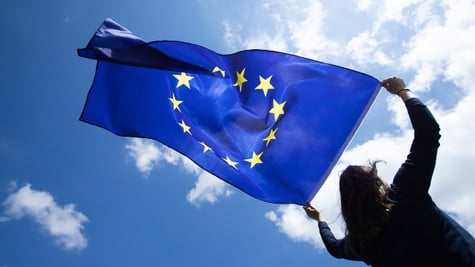 Person holding EU flag in the sky
