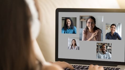 Person looking at PC screen and having a live meeting with multiple people