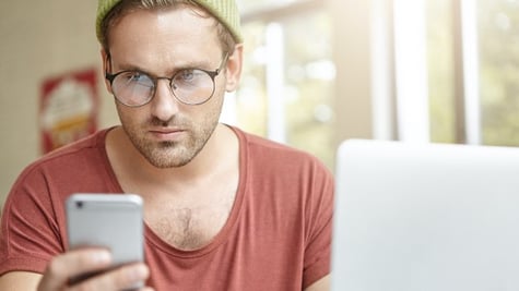hipster staring at a smartphone