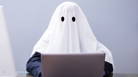 Human in ghost costume sitting