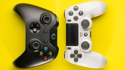 PS5 controller and Xbox controller put against each other