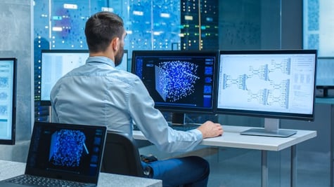 Man in front of multiple computers