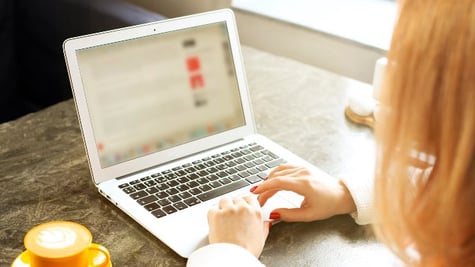 Woman using laptop with blurred screen