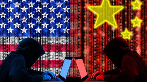 American hacker sitting opposite of a chinese hacker cyberwar concept in front of binary flags
