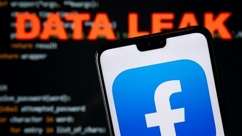 Facebook app logo seen on the smartphone and blurred DATA LEAK word with a brute force script on the