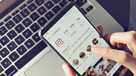 Woman holding smartphone with social internet service Instagram on the screen