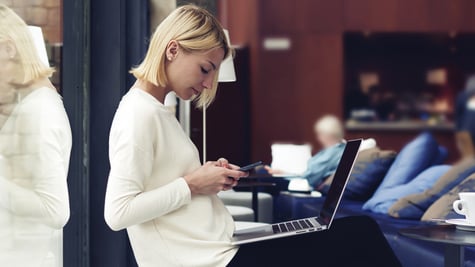 Woman with phone in front of her PC