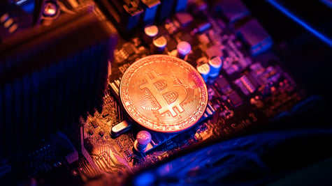 Bitcoin Cryptocurrency coin on a PC computer motherboard, crypto currency mining concept.
