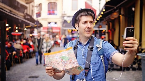 Backpacker Traveler Man traveling alone on crowded streets in old town