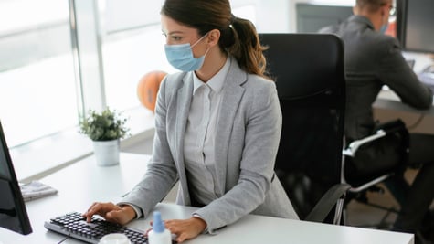 Businesswoman with medical mask working in office
