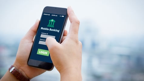 Female hands hold mobile banking on smart phone on blurred urban city as background
