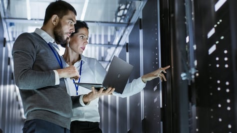 Female and Male employees discussing in data center