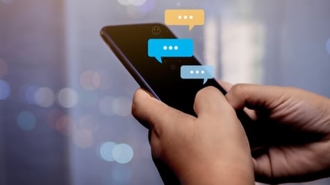 phone with text message bubbles in hands