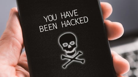 Haker alert concept. Modern smartphone with you have been hacked notification on screen in male's ha