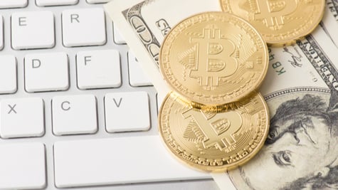 Bitcoins and dollars on the keyboard