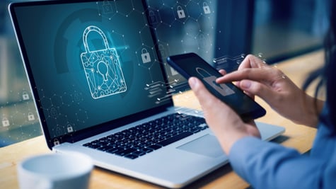 Person using pc and mobile with padlock on screen. Cyber insurance concept.