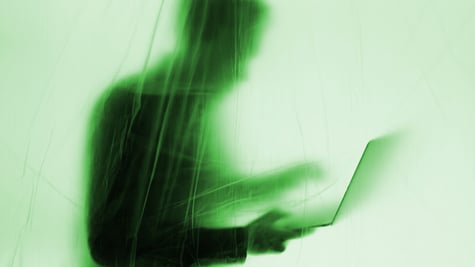 anonymous man with a computer behind a plastic curtain