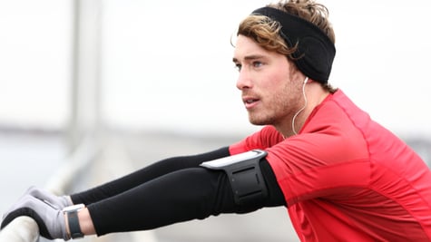 Male runner stretching after running