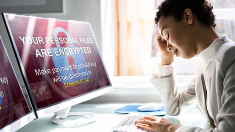 Worried woman using computer, suffers from a ransomware attack. Ransomware Malware Attack concept.