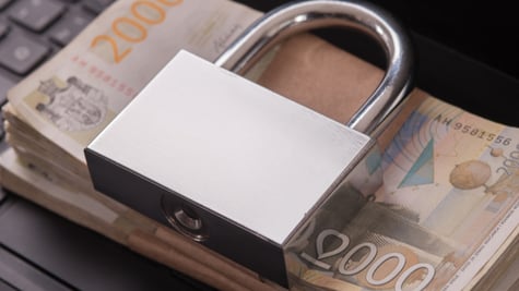 Pile of money with padlock on laptop keyboard. Ransomware