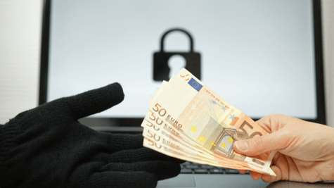 Black gloved hand taking 50 euro notes from bare hand with computer in background