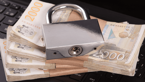 Keyboard, wads of cash, padlock piled on top of each other