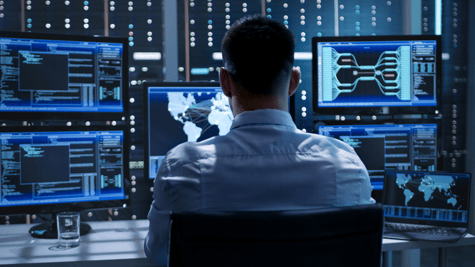 Man working with multiple computers, cybersecurity concept