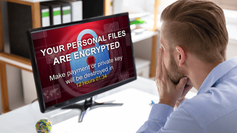 Businessman looking stressed as his computer files get encrypted