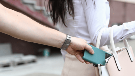 Glamorous woman having her mobile phone stolen from handbag