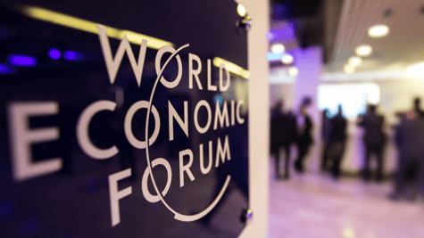 World Economic Forum signage with blurred delegates in background
