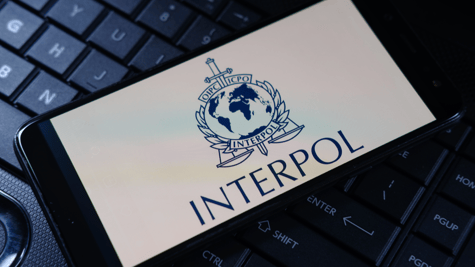 Phone with Interpol logo resting atop keyboard